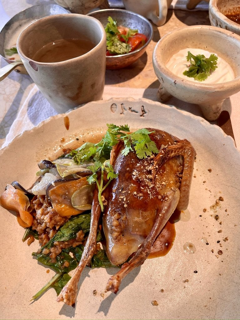 Roast pigeon on greens and grains