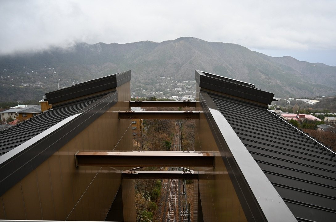 The track of the Hakone cable car running steeply downhill between station roofs