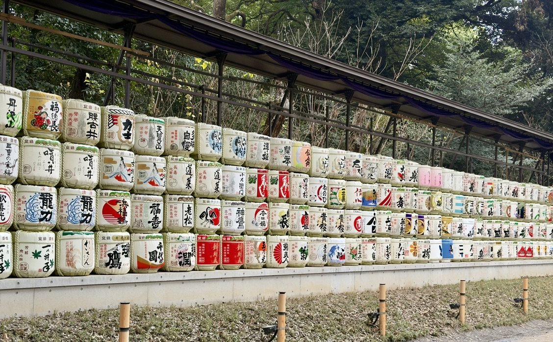 A long wall of decorated sake barrels at Meiji Jingu
