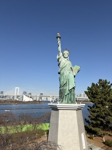 A replica of the Statue of Liberty in Odaiba, with the Rainbow Bridge across the bay