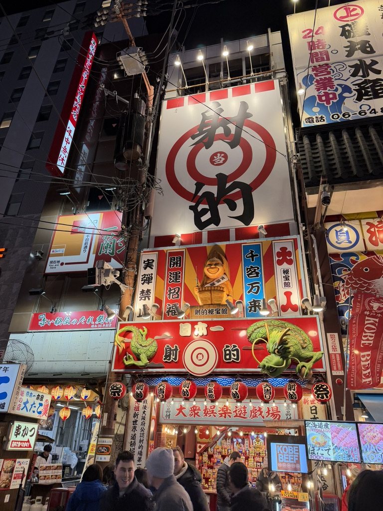 A brightly lit shooting-gallery storefront in Shinsekai