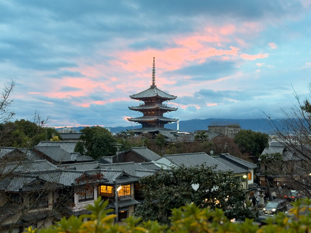 The five-story Yasaka pagoda above tiled rooftops at sunset