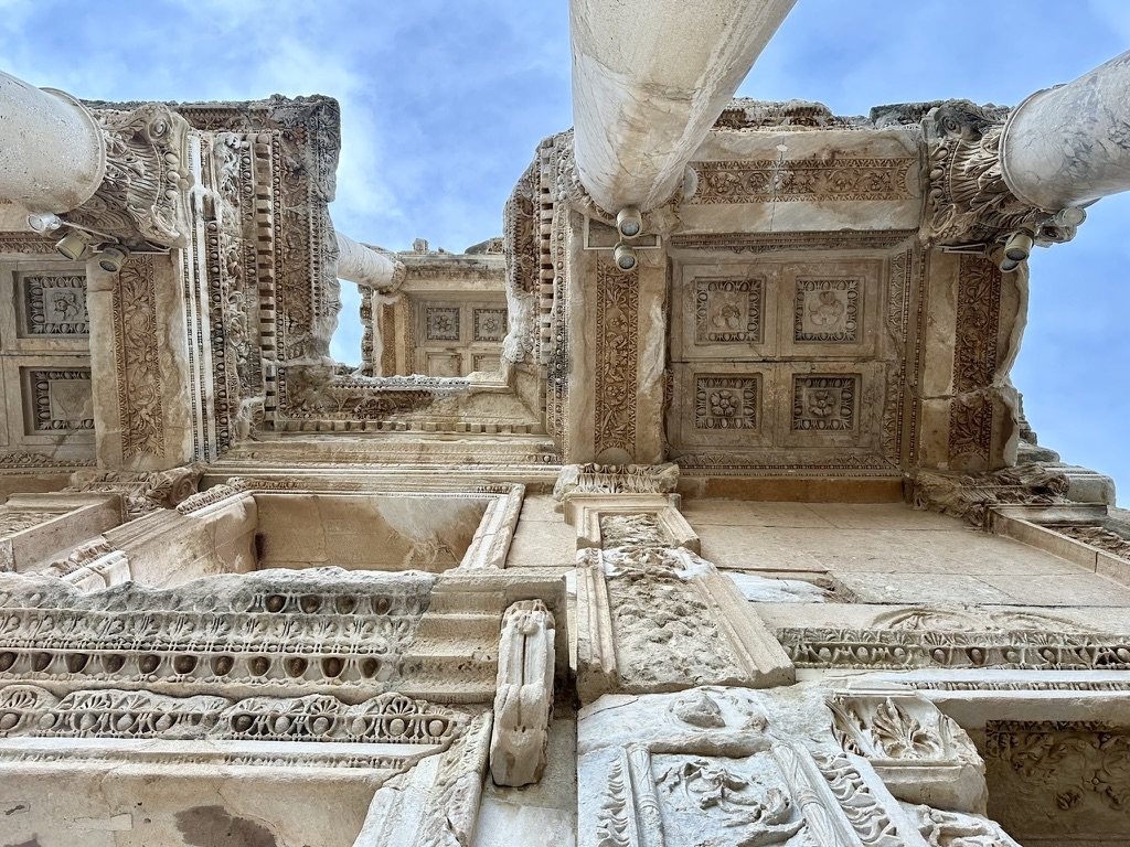 Looking straight up between the columns of the Library of Celsus at its carved, coffered ceilings