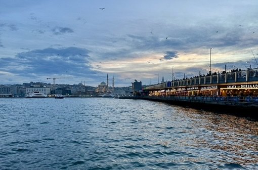 The Galata Bridge at dusk, with the domes and minarets of the New Mosque across the water
