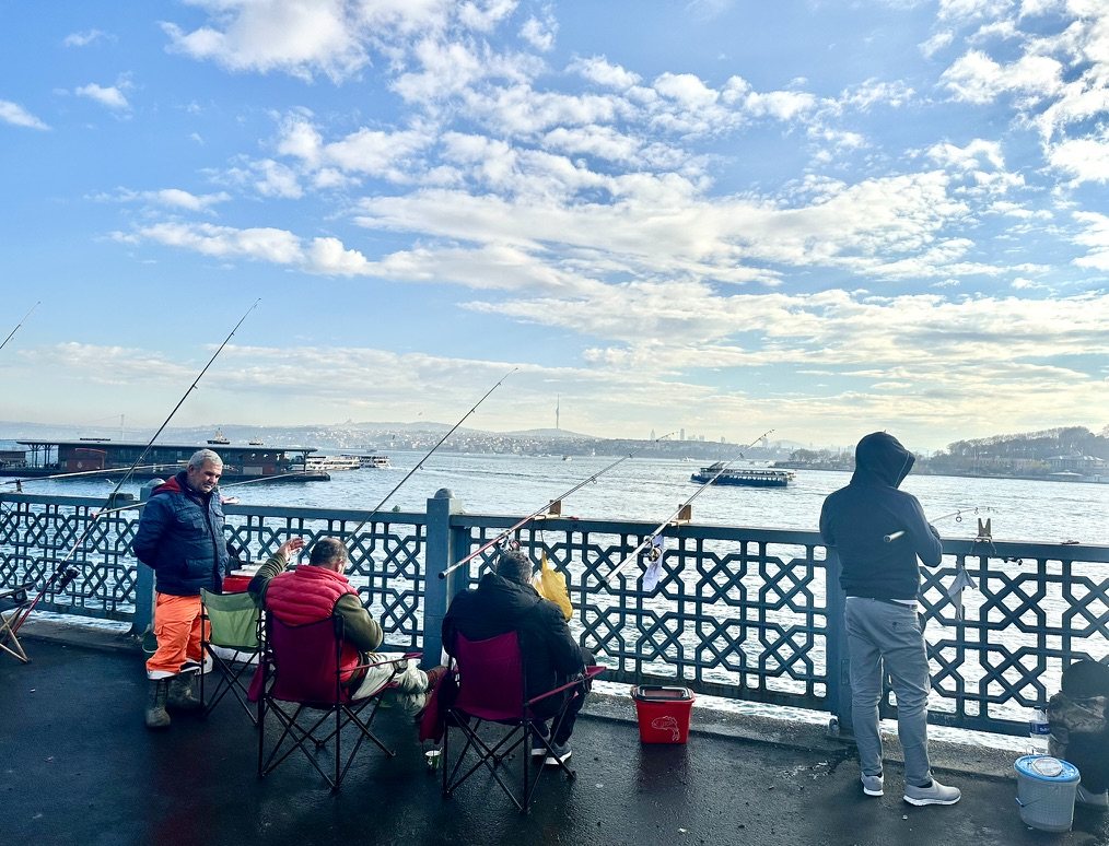 Fishermen with rods on the Galata Bridge, with the Bosphorus behind