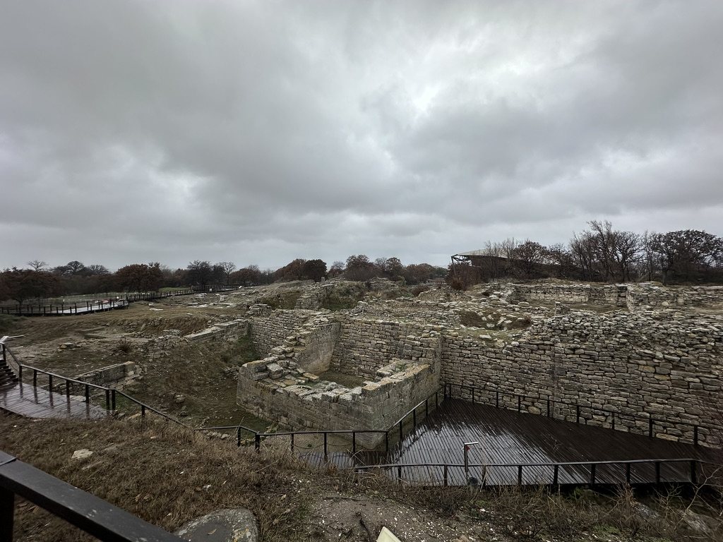 Walls of Troy below a grey sky, with wooden boardwalks around them